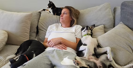 Woman relaxing on the sofa surrounded by rescue dogs