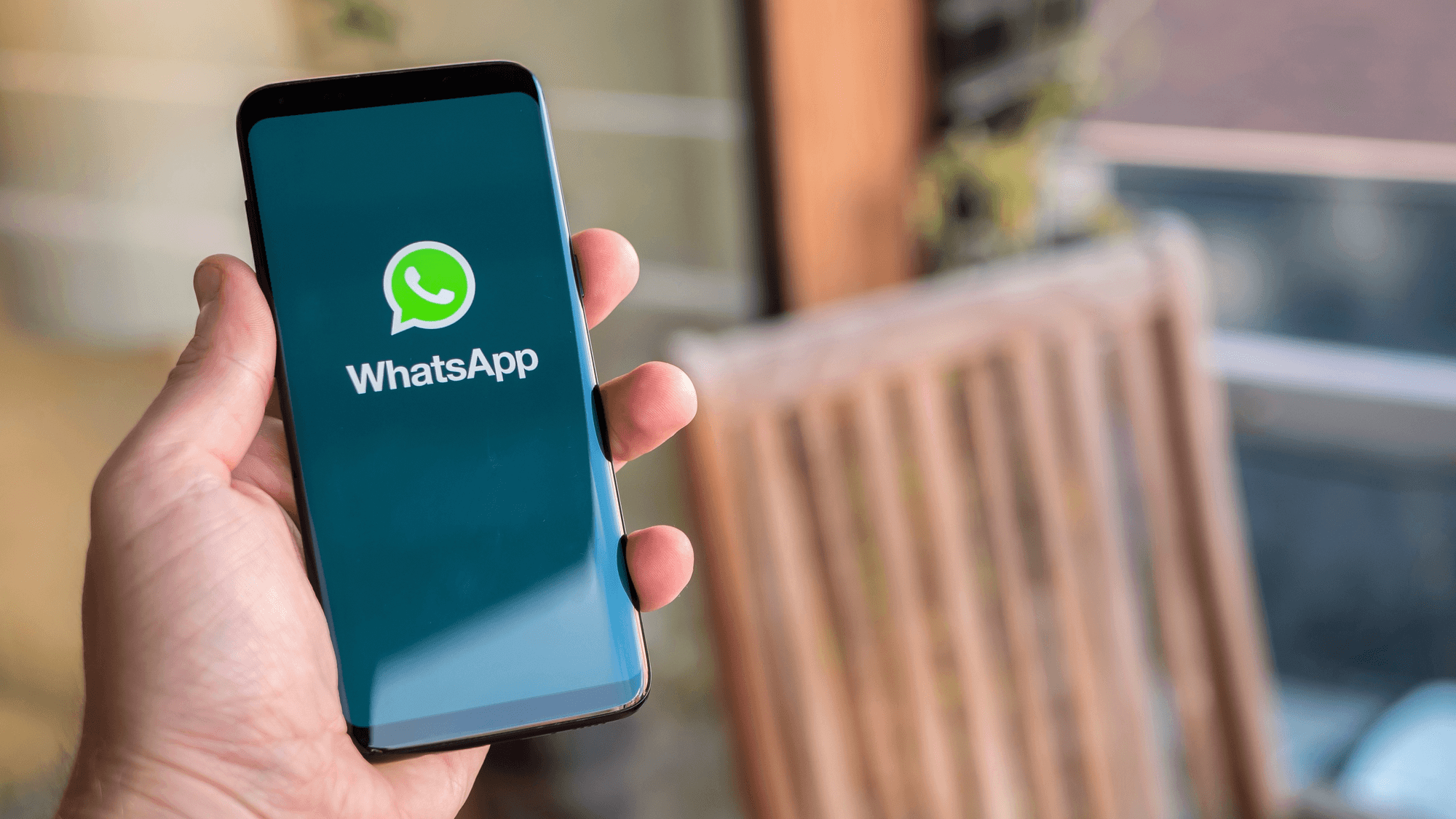Person holding phone with WhatsApp open